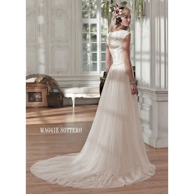 A flattering ruched bodice with feminine lace neckline and cap-sleeves is finished with crystal buttons over zipper and inner corset closure. Tulle stunning sheath wedding gown sparkles with swarovski crystal belt lace neckline cap-sleeves #utahbridalshop #weddinggowns #sandyutah #bridalcloset #brides #bridalshop #utahwedding #designerweddings #templeready #weddingaccessories #modestweddingdress