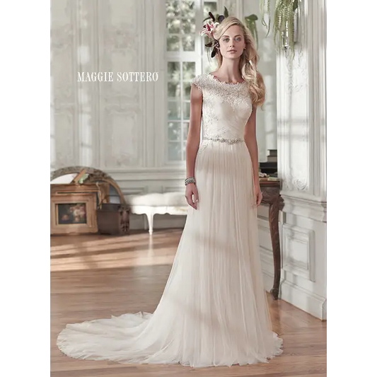 Comprised of barely-there tulle, this stunning sheath wedding gown sparkles with a delicate Swarovski crystal belt at the waist. Lace neckline cap-sleeves crystal buttons #utahbridalshop #weddinggowns #sandyutah #bridalcloset #brides #bridalshop #utahwedding #designerweddings #templeready #weddingaccessories #modestweddingdress